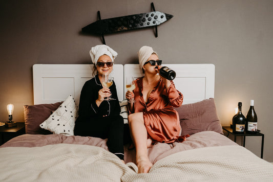 Frauen trinken Schaumwein im Bett